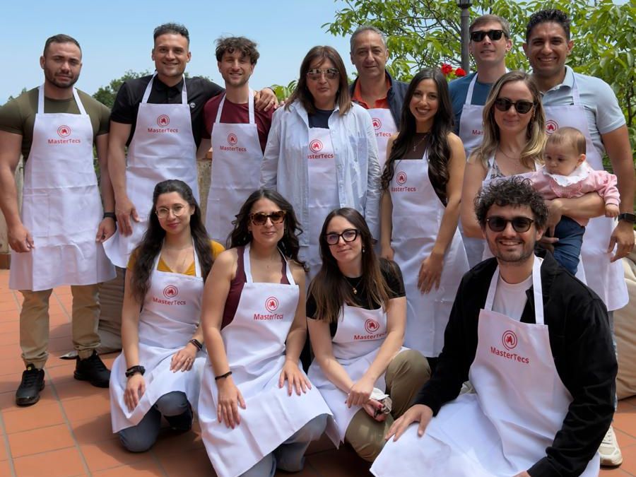 Il team Tecs in posa su una terrazza, con i grembiuli MasterTecs, alla giornata di team building per l'anniversario